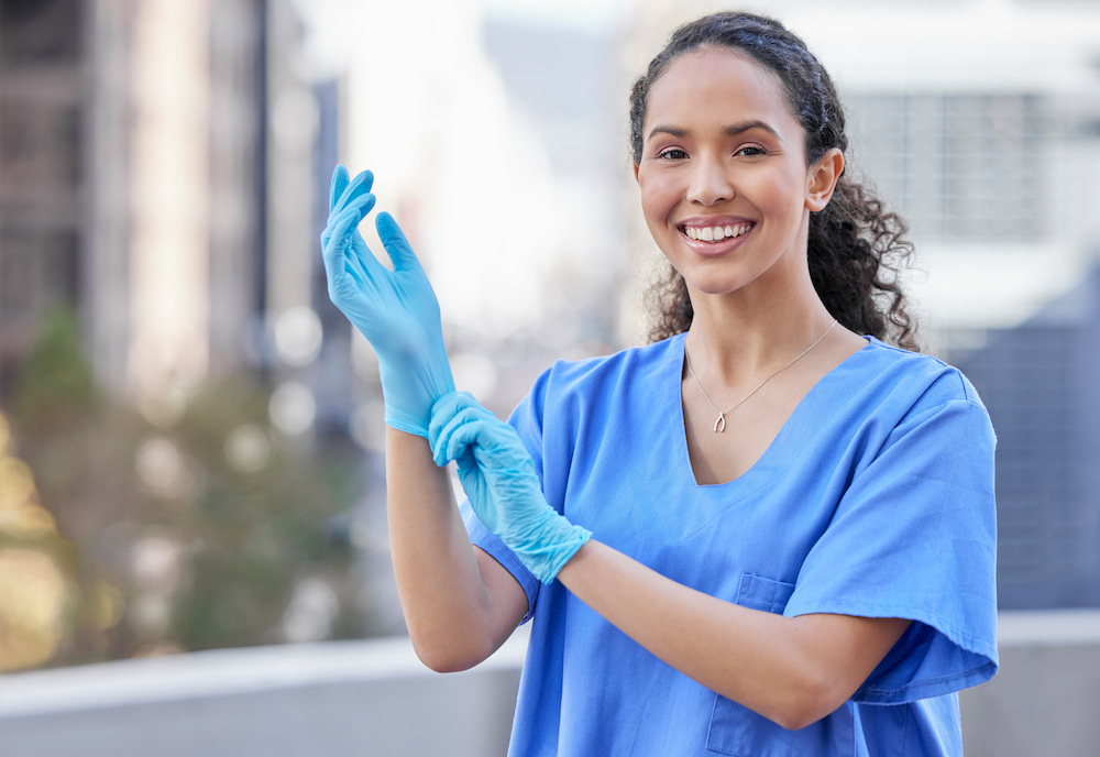 Shot of a female doctor putting gloves on her hand